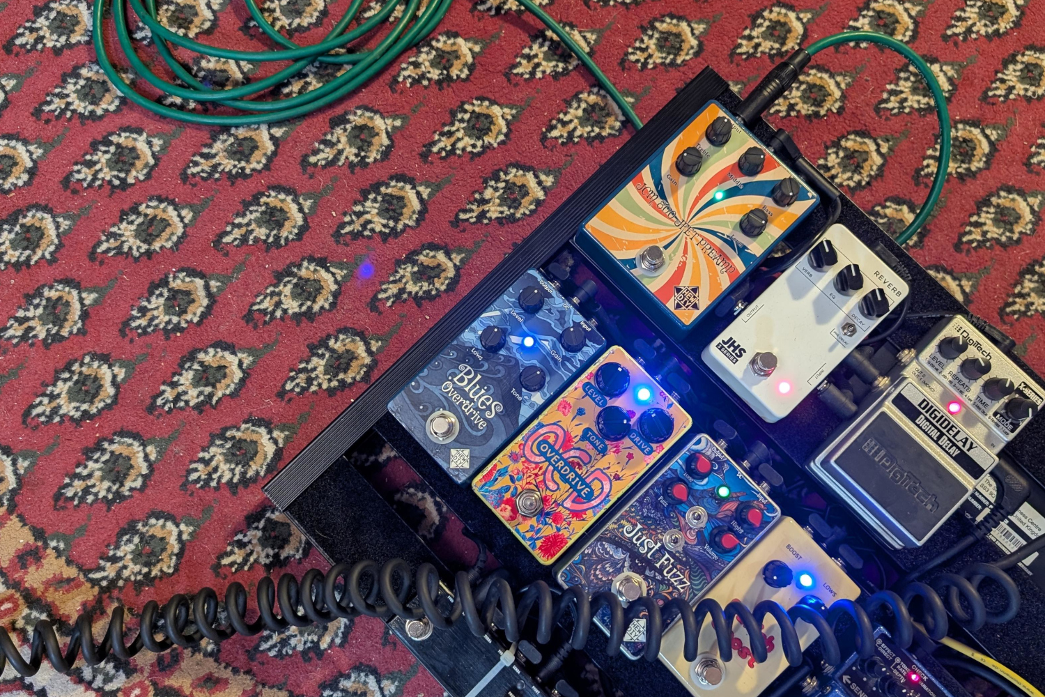 Guitar player's pedal board on a rug that really ties the room together.